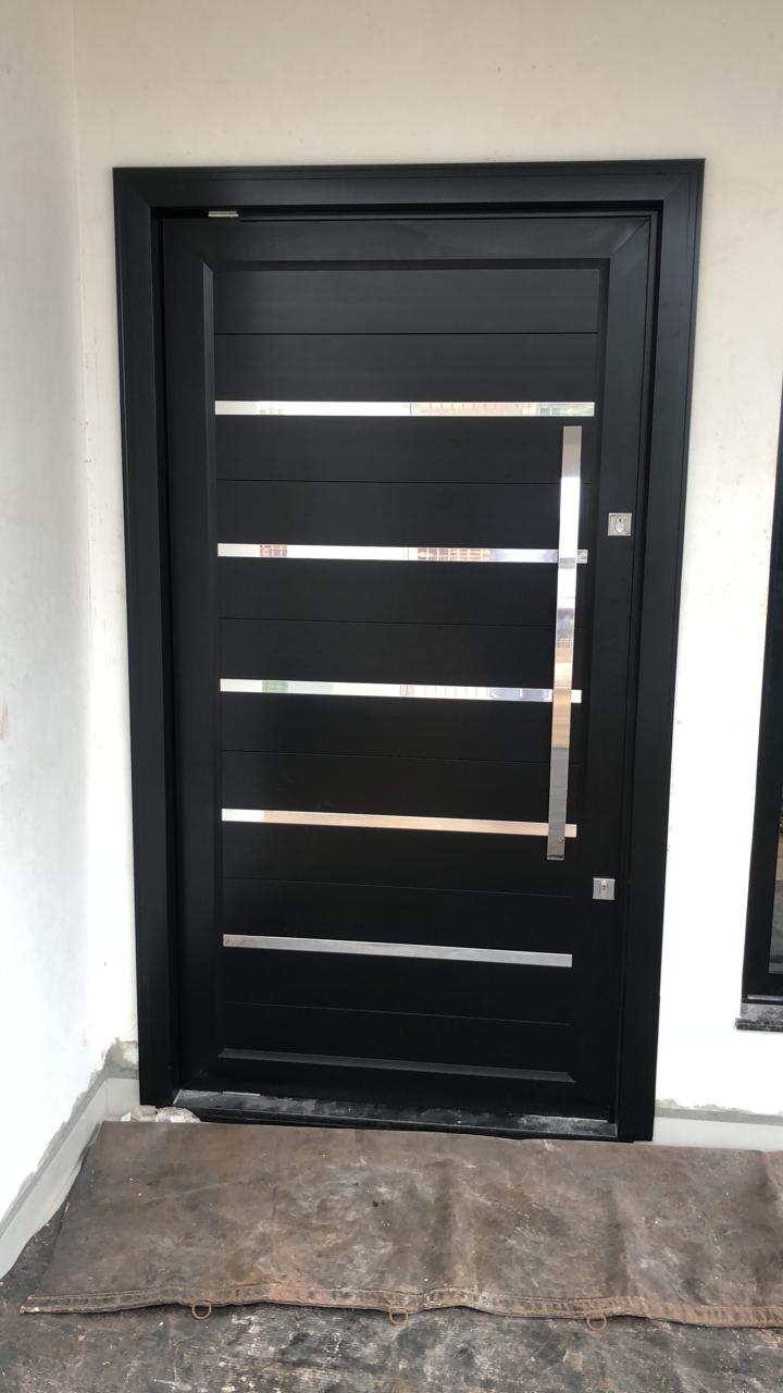 Porta pivotante preta com frisos em inox