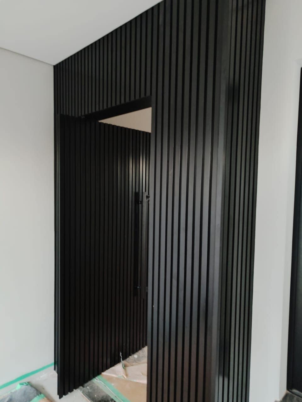 Painel ripado preto no hall