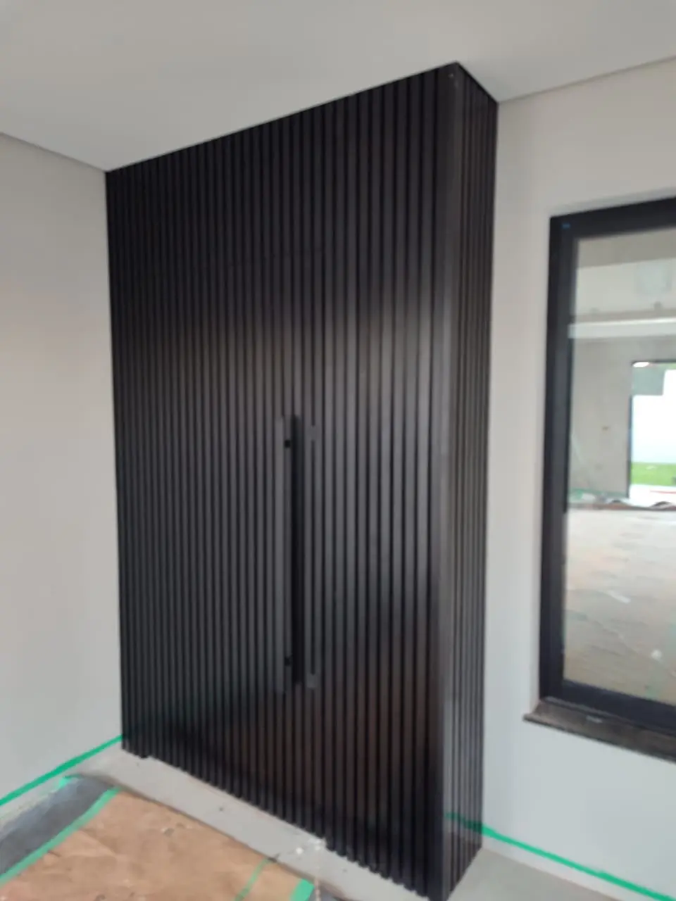 Entrada com porta e painel ripado