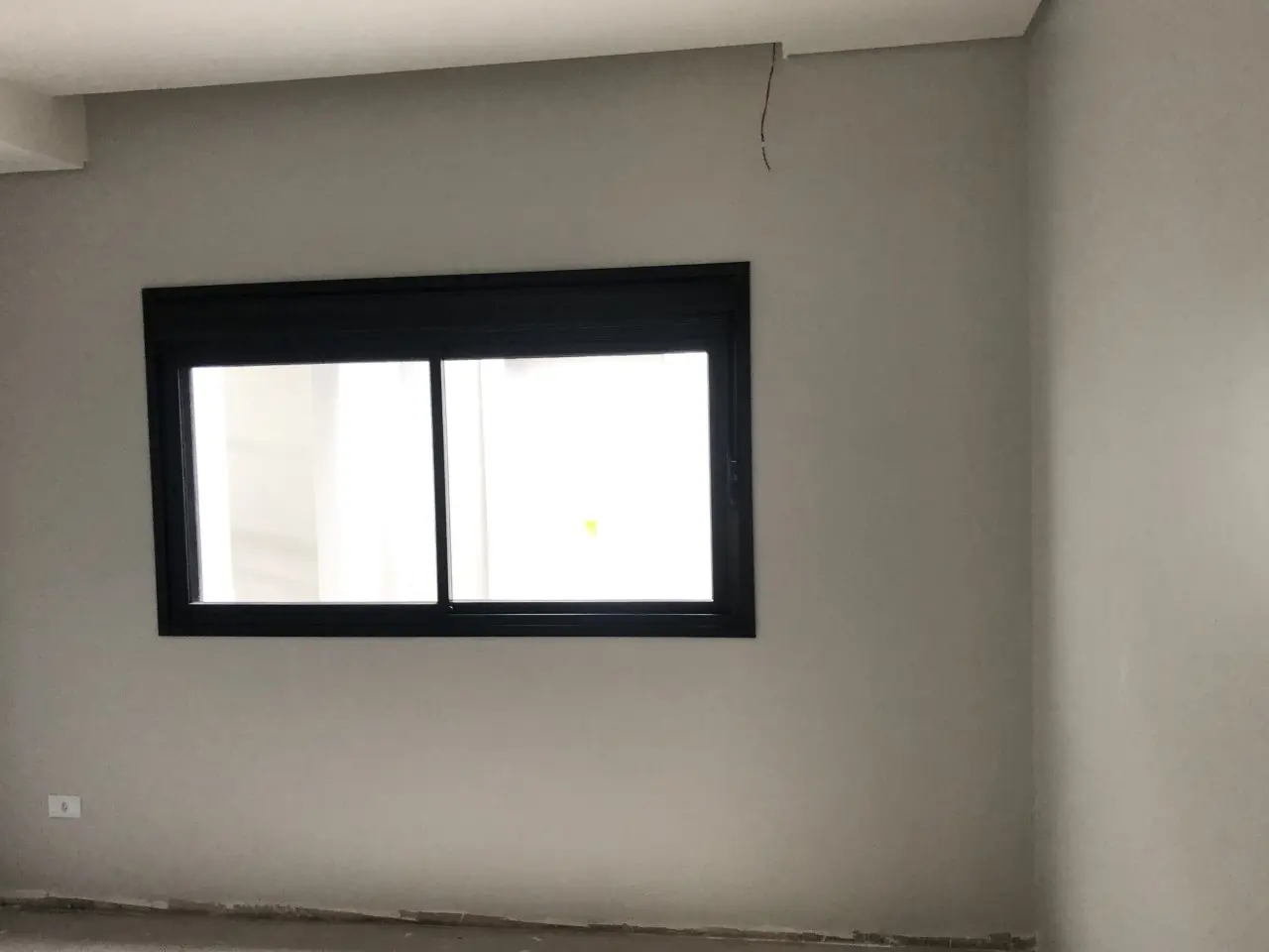 Janela preta com persiana de enrolar